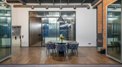 Interior of spacious dining room with round table and comfortable soft chairs placed in modern apartment