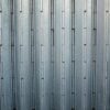 Close-up of a grey corrugated metal surface showcasing its uniform pattern and sturdy construction.