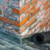Detailed view of a brick chimney featuring construction tools and materials for repair.