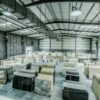 Expansive warehouse filled with large stone slabs for industrial use.