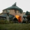 Striking modern house with artistic design and intriguing architecture, surrounded by lush greenery.