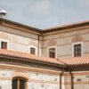 A detailed view of a historic stone building featuring red tiled roofs and classic architecture.