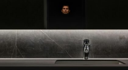 Sleek bathroom interior with marble surfaces and a reflective mirror adding to the luxurious ambiance.