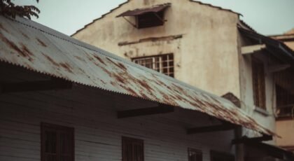 Aged building with a rusted metal roof, highlighting architectural decay.