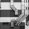 Monochrome image showcasing industrial ductwork and vents on a striped building exterior.