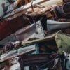 Close-up view of rusted cars stacked in a junkyard, showcasing decay and waste.