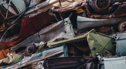Close-up view of rusted cars stacked in a junkyard, showcasing decay and waste.