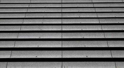 Aerial view of a monochromatic corrugated roof pattern emphasizing repetition and texture.