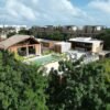 Aerial view of a luxury villa with a private pool nestled in the lush jungle of Tulum, Mexico.