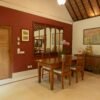 A serene Balinese dining room with vintage decor and wooden furniture, exuding warmth and elegance.