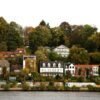 Picturesque riverside neighborhood with colorful houses and lush trees in Finland.