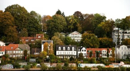 Picturesque riverside neighborhood with colorful houses and lush trees in Finland.