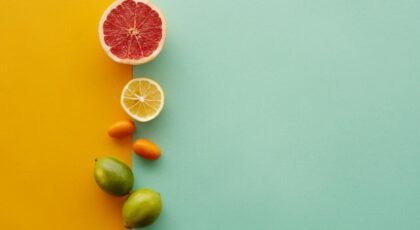 Colorful arrangement of citrus fruits on a bright split background for a fresh, healthy vibe.