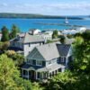 Scenic view of coastal homes by the sea with a lighthouse in the background.