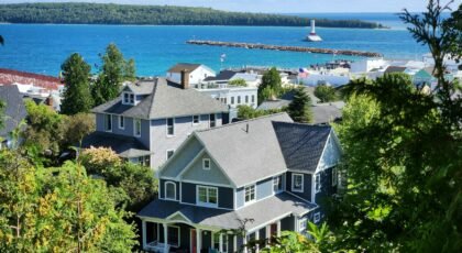 Scenic view of coastal homes by the sea with a lighthouse in the background.