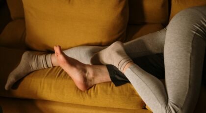 A couple snuggling together on a comfortable yellow sofa at home.