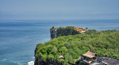 Majestic cliffside views overlooking the sea in Bali, highlighting lush greenery and architecture.