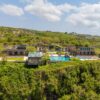 Aerial view of a luxurious villa with an infinity pool on a cliffside in Bali, Indonesia.
