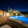Experience luxury in a Mediterranean villa poolside at night, perfect for relaxation.