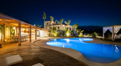 Experience luxury in a Mediterranean villa poolside at night, perfect for relaxation.