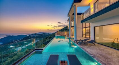 Stunning luxury villa overlooking the ocean with an infinity pool at sunset.