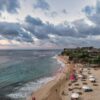 Stunning aerial view of a beach in Bali, Indonesia with visitors at sunset.