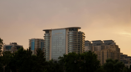 Capture of Baku's urban skyline at dusk featuring modern architecture and a luxury hotel.
