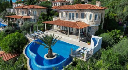 Elegant villa with stunning infinity pool surrounded by lush greenery and scenic views.