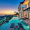 Stunning luxury villa overlooking the ocean with an infinity pool at sunset.