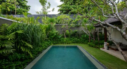 Luxurious villa pool surrounded by lush tropical greenery in Bali, Indonesia.