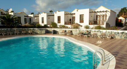 Relax by the pool at a luxurious holiday resort under sunny summer skies.