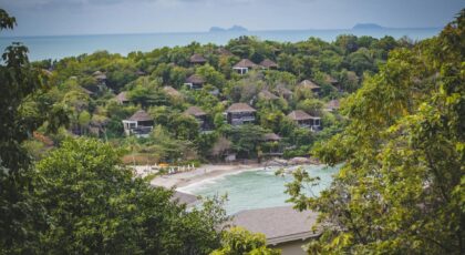 Tropical retreat with villas overlooking a pristine beach and lush greenery, ideal for a serene getaway.