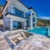 Stunning contemporary villa with glass, stone, and infinity pool; perfect for luxury living.