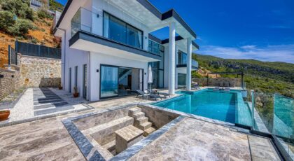 Stunning contemporary villa with glass, stone, and infinity pool; perfect for luxury living.