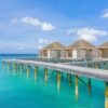 Idyllic scene of overwater bungalows in Maldives with turquoise ocean and clear sky.