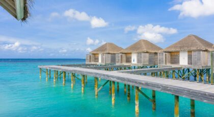 Idyllic scene of overwater bungalows in Maldives with turquoise ocean and clear sky.