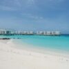 Luxurious overwater villas on a pristine beach with turquoise waters and clear blue skies.