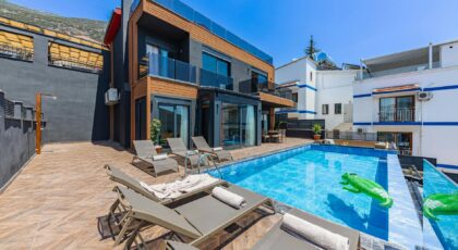 Contemporary villa with a private swimming pool and sun loungers, ideal for a luxury vacation.